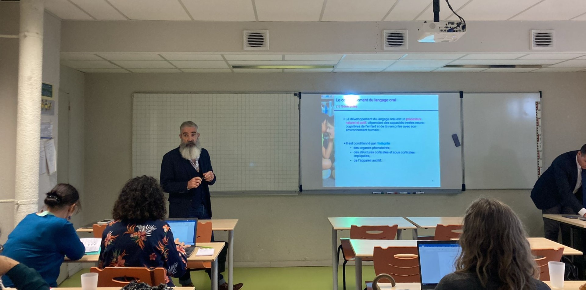 Intervenant au tableau devant les participants du séminaire