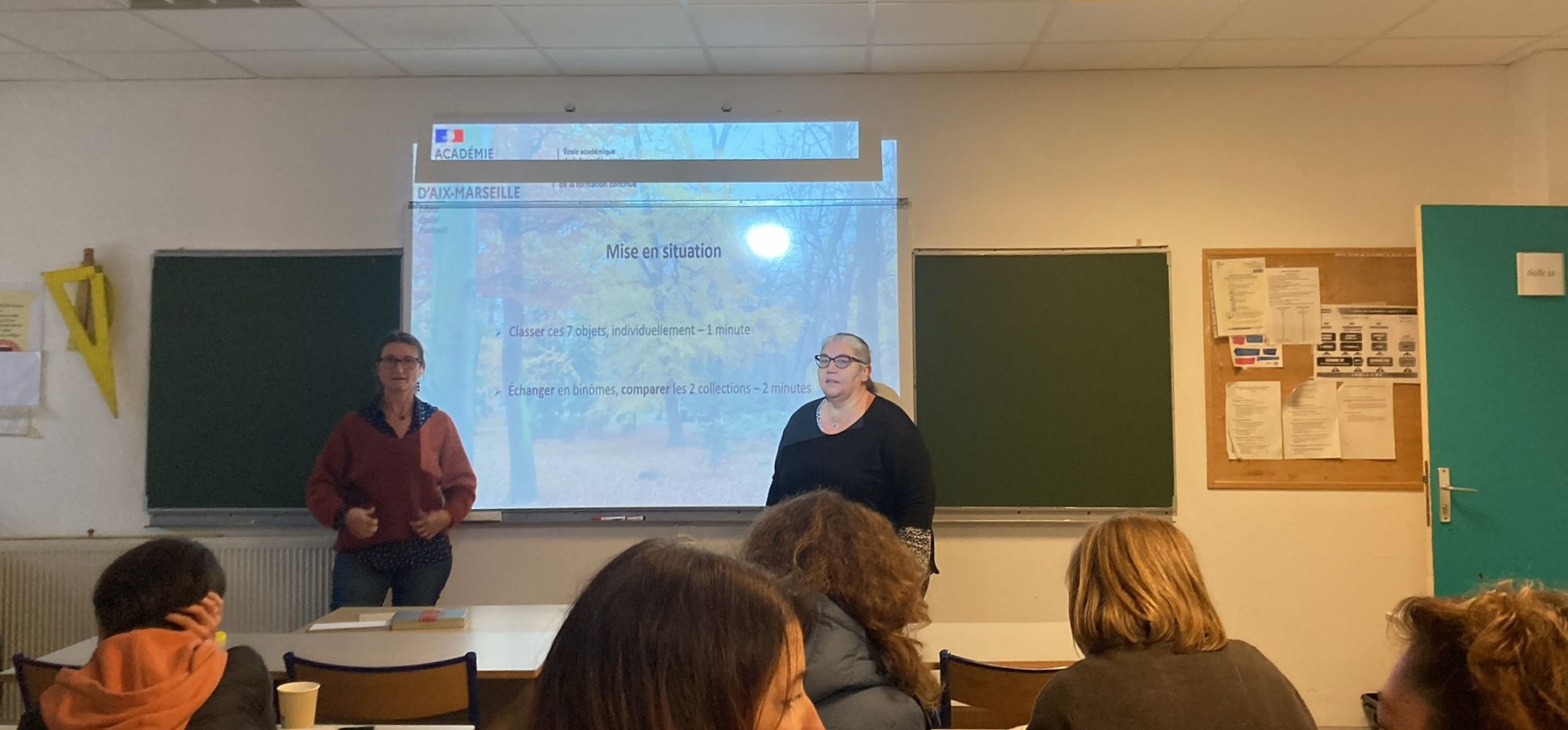 Intervenant au tableau devant les participants du séminaire
